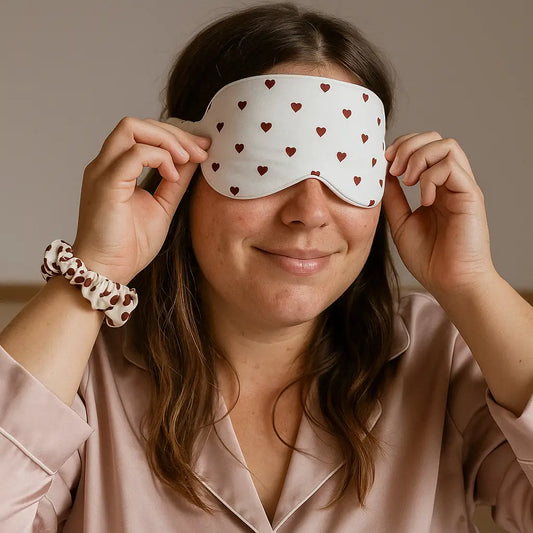 Femme portant un masque chauffant réfrigérant pour les yeux - motifs coeurs rouges