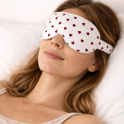 Femme portant un masque chauffant réfrigérant pour les yeux - motifs coeurs rouges