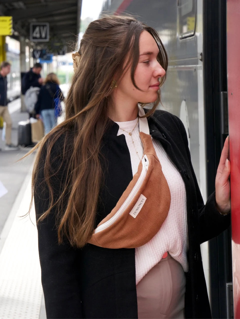 Femme portant un sac banane en velours caramel