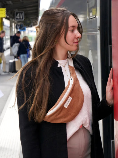 Femme portant un sac banane en velours caramel