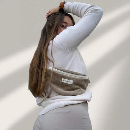 Femme portant un sac banane en velours de couleur taupe, fabriqué en France